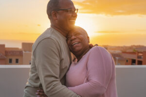 senior couple laughing and hugging each other on a rooftop